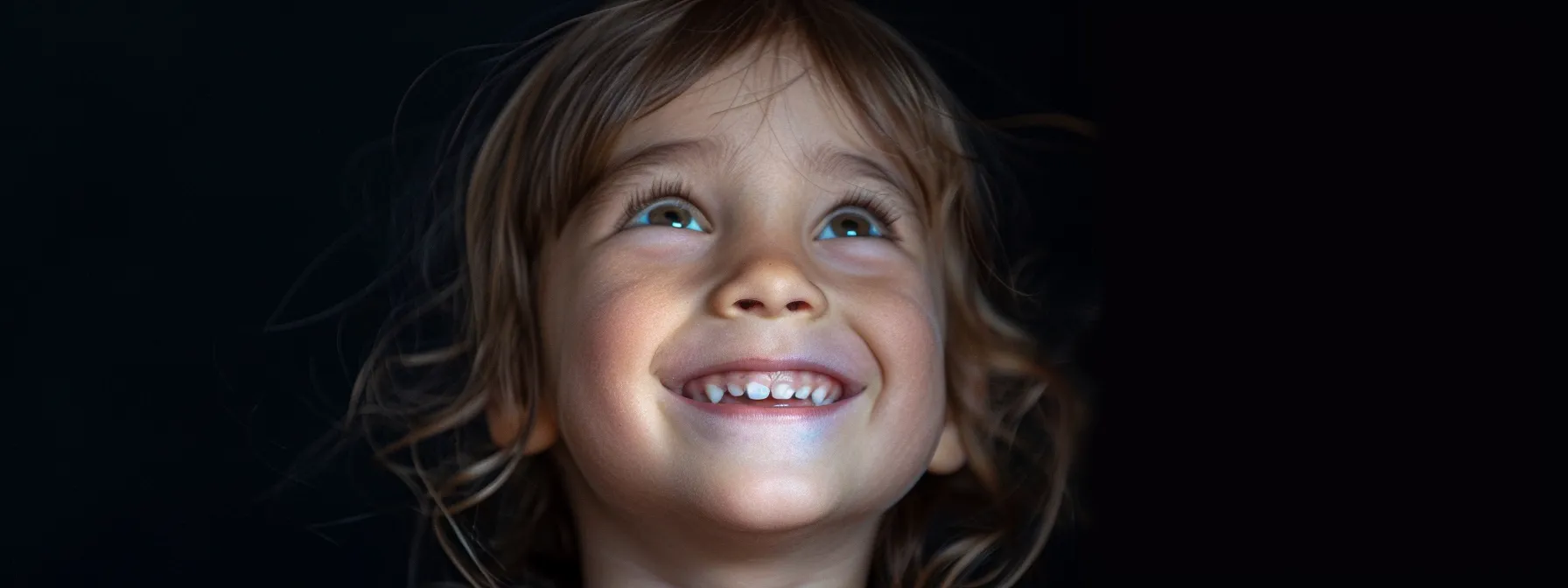 a child with straight teeth and a balanced facial profile smiling confidently.